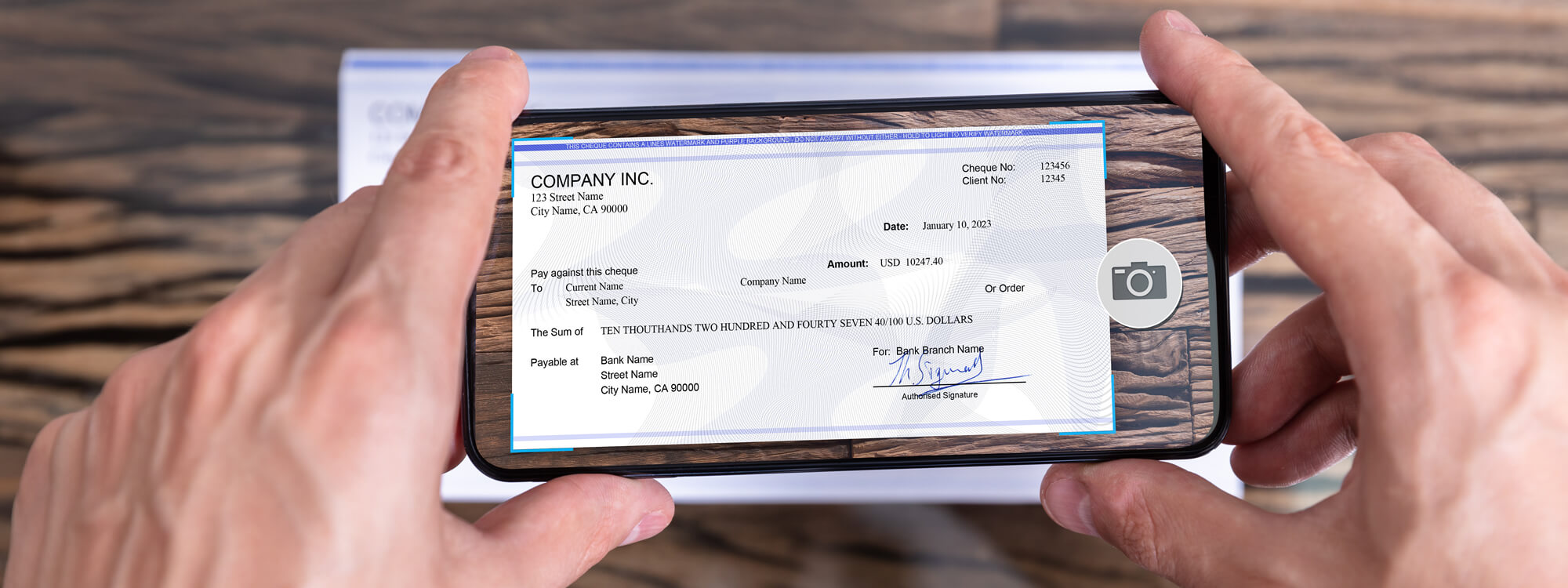 Banner for mobile deposit showing a check being deposited with a cell phone.