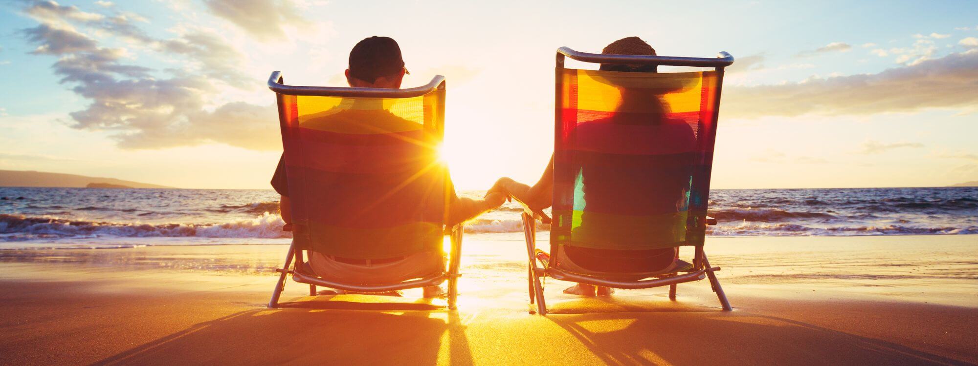 Banner for golden rewards showing a couple holding hands sitting at the beach.