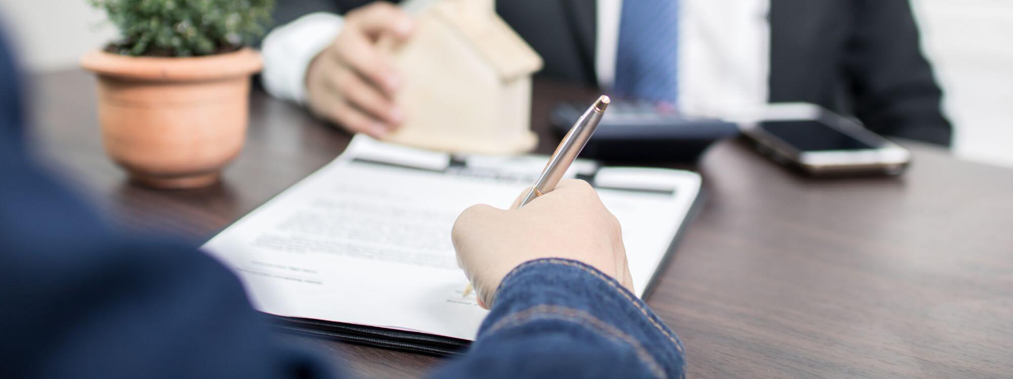 Banner for lending showing a person signing a contract.