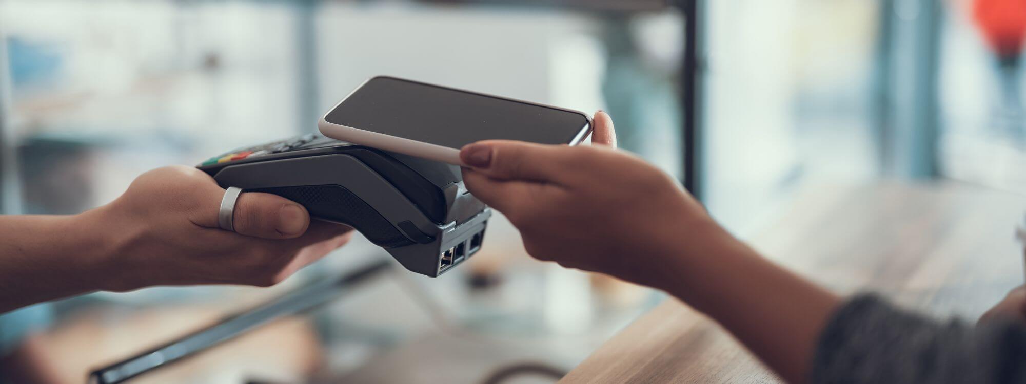 Banner for on the go showing a person paying with their phone.